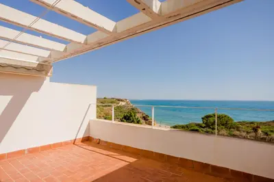 a white bathroom with a toilet and a sink at Casas Fuente del Sol in Conil de la Frontera