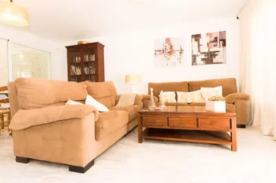 a white bedroom with a large bed and a window at Casas Fuente del Sol in Conil de la Frontera
