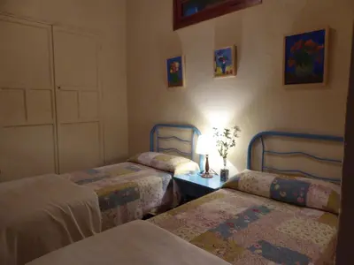 a bedroom with two beds and a table with a lamp at Jerez Viña Santa Petronila in Jerez de la Frontera