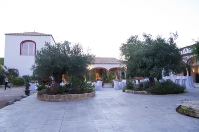 a courtyard with tables and trees in front of a building at Jerez Viña Santa Petronila in Jerez de la Frontera