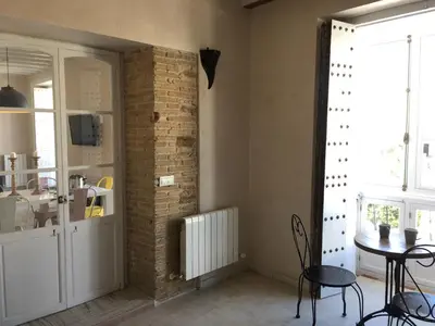 a room with a table and a brick wall at Casa Bugambilla Cadiz in Cádiz