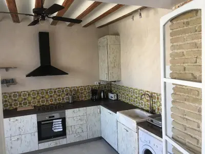 a kitchen with white cabinets and a ceiling fan at Casa Bugambilla Cadiz in Cádiz