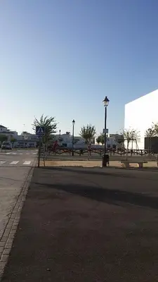 an empty street with a park with a playground at Tabano in Chipiona