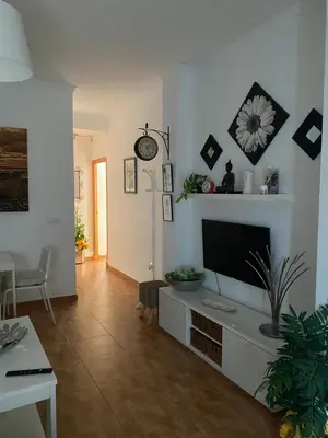 a living room with a television on a white wall at Tabano in Chipiona