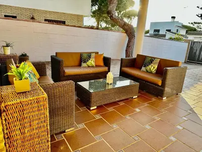 a patio with wicker chairs and a coffee table at Chalet Nora in Chiclana de la Frontera