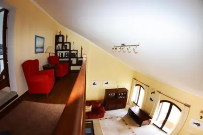 a living room with red chairs and a staircase at Chalet Nora in Chiclana de la Frontera