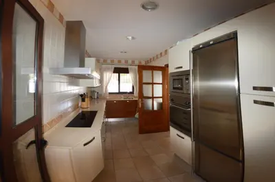 a kitchen with a sink and a refrigerator at Chalet Nora in Chiclana de la Frontera