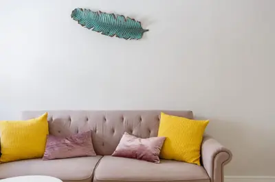 a couch with yellow and pink pillows on it at Apartamento El SABIO by Cadiz4Rentals in Cádiz