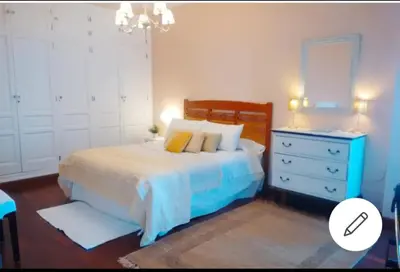 a bedroom with a bed with a dresser and a mirror at Piso Ribera del Marisco in El Puerto de Santa María