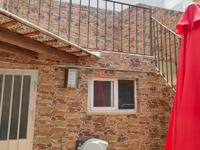 a brick house with a window and a staircase at Isabelita in Rota