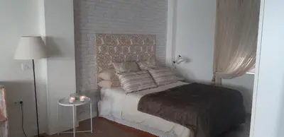 a small bedroom with a bed and a side table at Estudio Deluxe Playa de la Victoria in Cádiz