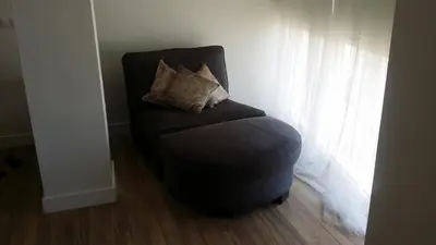 a chair with two pillows sitting in a room at Estudio Deluxe Playa de la Victoria in Cádiz