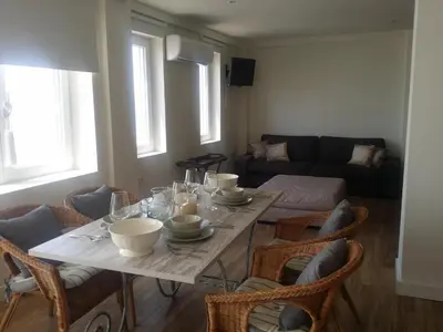 a living room with a table and chairs and a couch at Estudio Deluxe Playa de la Victoria in Cádiz