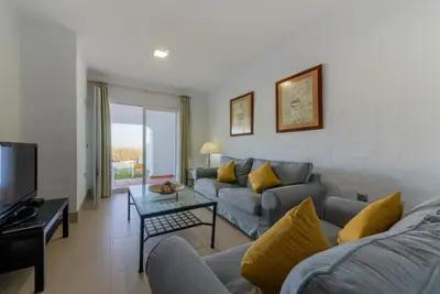a living room with a couch and a tv at Villas Flamenco Beach Conil in Conil de la Frontera