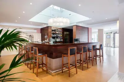 a kitchen with a bar with wooden stools at Hipotels Flamenco Conil in Conil de la Frontera