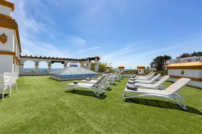 a row of chaise lounge chairs on a lawn at Hipotels Flamenco Conil in Conil de la Frontera