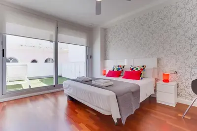 a bedroom with a large white bed with red pillows at El Atico del MARQUES free parking by Cadiz4Rentals in Cádiz