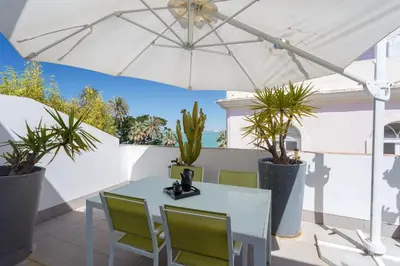 a table and chairs under an umbrella on a patio at El Atico del MARQUES free parking by Cadiz4Rentals in Cádiz