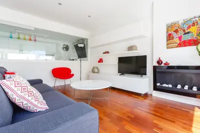 a living room with a blue couch and a tv at El Atico del MARQUES free parking by Cadiz4Rentals in Cádiz