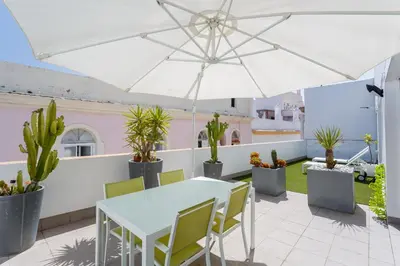 a patio with a white table and chairs and potted plants at El Atico del MARQUES free parking by Cadiz4Rentals in Cádiz