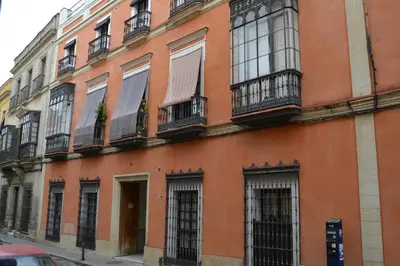 an orange building with windows and balconies on a street at Sherryflat Caballeros - Parking in Jerez de la Frontera