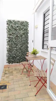 a table and chairs in front of a wall at Sherryflat Caballeros - Parking in Jerez de la Frontera