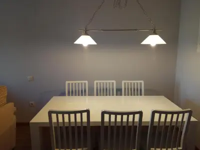 a dining room table with four chairs and three lights at Apartamento La Ermita Wifi in Jerez de la Frontera
