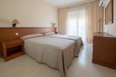 a hotel room with a bed and a window at Aparthotel las Dunas in Chiclana de la Frontera