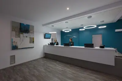an office with two people sitting at a reception counter at Aparthotel las Dunas in Chiclana de la Frontera