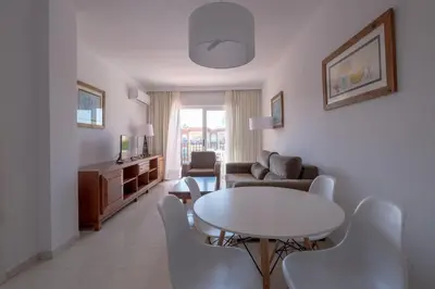 a living room with a table and a couch at Aparthotel las Dunas in Chiclana de la Frontera