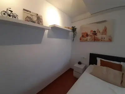 a bedroom with a bed and a bike on the wall at Casa Caleta a 2 minutos de la playa in Cádiz