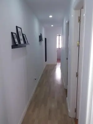 a hallway with white walls and a wooden floor at Casa Caleta a 2 minutos de la playa in Cádiz