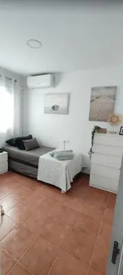 a bedroom with a bed and a table in it at Casa Caleta a 2 minutos de la playa in Cádiz