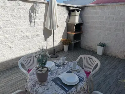 a table and chairs on a patio with an umbrella at Casasjerezanas Loft Las Flores in Jerez de la Frontera