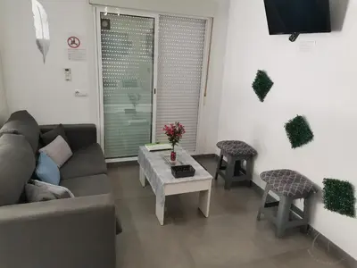 a kitchen with a stainless steel refrigerator and a couch at Casasjerezanas Loft Las Flores in Jerez de la Frontera