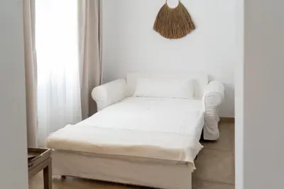 a white bed in a room with a window at Moorea Boutique - Only Adults in Chiclana de la Frontera
