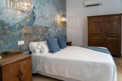 a bedroom with a bed and a painting on the wall at Moorea Boutique - Only Adults in Chiclana de la Frontera