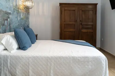 a bedroom with a bed with blue pillows at Moorea Boutique - Only Adults in Chiclana de la Frontera