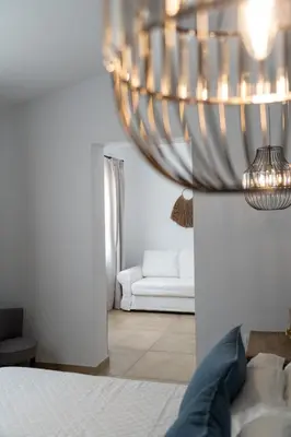 a living room with a bed and a chandelier at Moorea Boutique - Only Adults in Chiclana de la Frontera