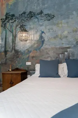 a bedroom with a bed and a painting of a bird at Moorea Boutique - Only Adults in Chiclana de la Frontera
