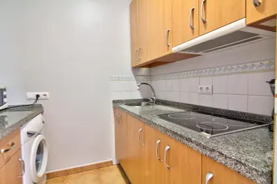 a small kitchen with a sink and a stove at Apartamentos Centro 2 el Puerto in El Puerto de Santa María