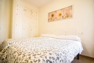 a bedroom with a bed with a flower painting on the wall at Apartamentos Centro 2 el Puerto in El Puerto de Santa María