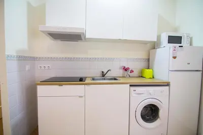 a kitchen with a white refrigerator and a washing machine at Apartamentos Centro 2 el Puerto in El Puerto de Santa María