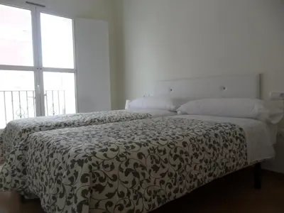 a bedroom with a bed with a black and white comforter at Apartamentos Centro 2 el Puerto in El Puerto de Santa María