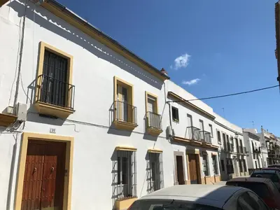 a white building with balconies and cars parked on a street at Apartamento Cielo 35 in El Puerto de Santa María
