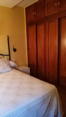 a bedroom with a white bed with wooden cabinets at Apartamento Cielo 35 in El Puerto de Santa María