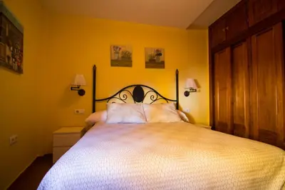a bedroom with a large bed with yellow walls at Apartamento Cielo 35 in El Puerto de Santa María