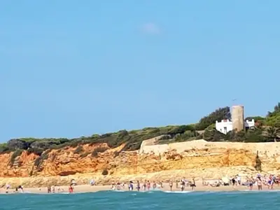 a group of people on a beach near the water at El Campanario in Chiclana de la Frontera