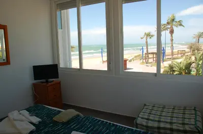 a bedroom with a window with a view of a beach at El Campanario in Chiclana de la Frontera