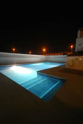 a large swimming pool at night with blue lights at Casa Paco in Chiclana de la Frontera